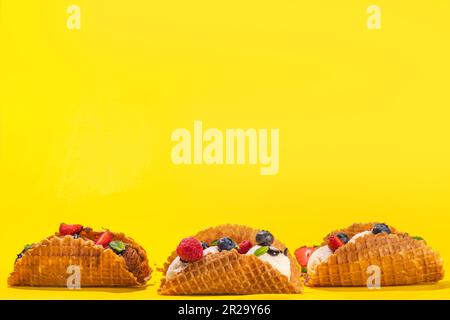 Diverses crèmes glacées au taco sucré. Coquilles de tacos à gaufrer avec glace au chocolat et à la vanille avec différents fruits, baies, garnitures Banque D'Images