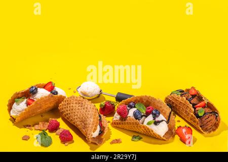 Diverses crèmes glacées au taco sucré. Coquilles de tacos à gaufrer avec glace au chocolat et à la vanille avec différents fruits, baies, garnitures Banque D'Images