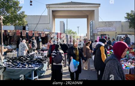 Sousse, Tunisie, 15 janvier 2023: Entrée au marché du dimanche à Sousse avec de nombreuses femmes et étals vendant des chaussures Banque D'Images