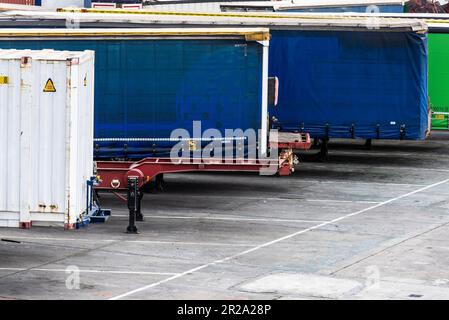 Barcelone, Espagne - 17 avril 2023: Remorques à conteneurs garées en rangée dans le quai de chargement attendant d'embarquer au port de Barcelone, Catalogne, Espagne Banque D'Images