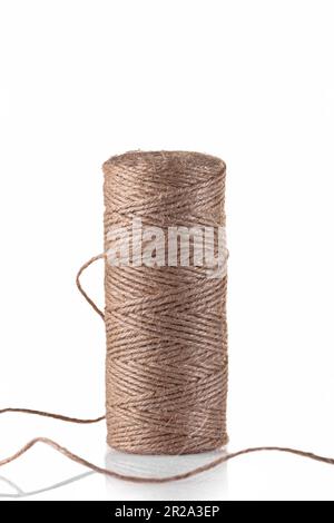 Corde de jute pour emballer des cadeaux et divers objets d'artisanat. Une bobine de corde sur fond blanc. Isoler. Banque D'Images