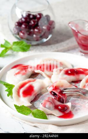 Dessert chaud. Boulettes de cerises à la sauce sucrée. Plats végétariens. Banque D'Images