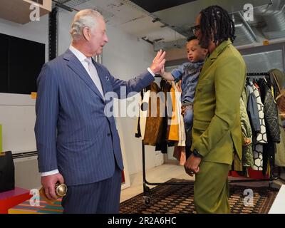 L'APPROBATION DES PARENTS ACCORDÉE par le roi Charles III donne un cinq à Idris, 2 ans, fils de Foday Dumbuya (à droite), fondateur et directeur créatif de LABRUM London, lors d'un événement spécial organisé par le British Fashion Council (BFC) à 180 Studios, Londres. Date de la photo: Jeudi 18 mai 2023. Banque D'Images