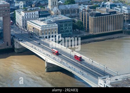 Londres, Angleterre-août 2022 ; vue de haut niveau de deux bus à double pont rouge vif sur le London Bridge traversant la Tamise Banque D'Images