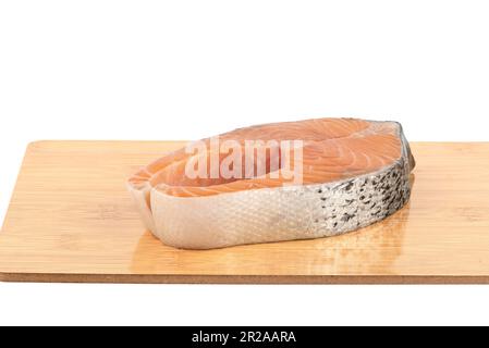 Steak de saumon, tranche de poisson rouge frais brut sur la planche à découper isolée sur fond blanc, pleine profondeur de champ. Copier l'espace. Banque D'Images