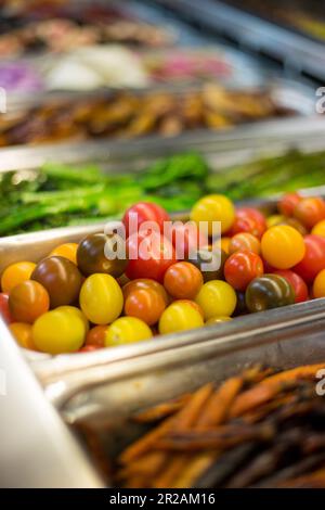 Gros plan d'une variété de petites tomates colorées pour bébé Heirloom dans un bar à salades Banque D'Images