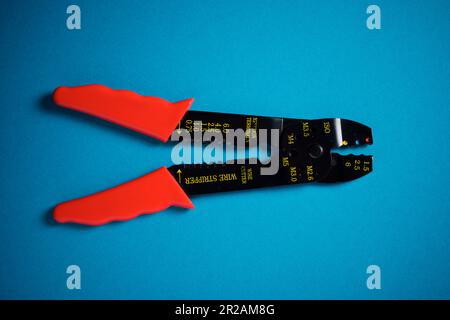 Pince à dénuder et coupe-fil pour couper le câble électrique sur une table  bleue Photo Stock - Alamy