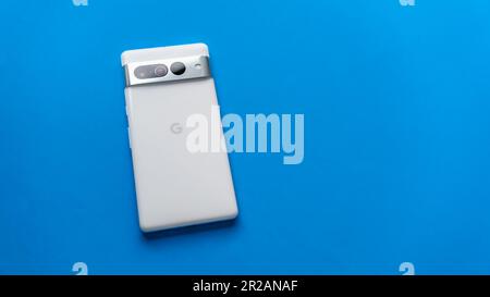 Los Angeles, Californie – 29 mars 2023: Google Pixel 7 Pro, en blanc neige, sur fond bleu. Le téléphone est allumé face vers le bas, l'arrière étant illustré. Banque D'Images