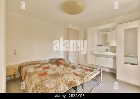 une chambre avec un lit, une commode et un miroir sur le mur en face de la chambre est de couleur très blanche Banque D'Images