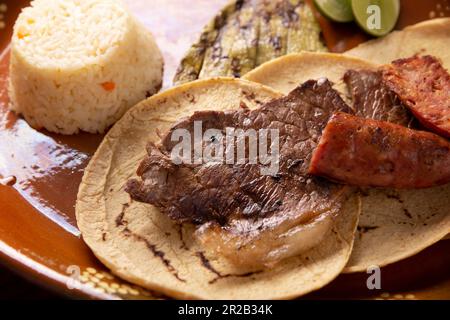 Taco style campechano, Carne Asada. (Viande rôtie) et chorizo ou longaniza, plat très populaire dans le nord du Mexique, également appelé Asado, Discada ou Parrill Banque D'Images