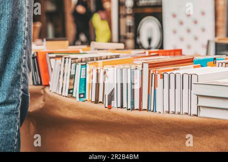 Piles de livres couchés sur table, marché aux puces, commerce de rue, scène de rue réelle, foyer sélectif. Style de vie en ville, éducation, lecture fiction concept Banque D'Images