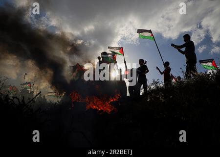 Gaza. 18th mai 2023. Le peuple palestinien participe à une manifestation pour rejeter la marche du drapeau israélien près de la clôture de la frontière Gaza-Israël, à l'est de la ville de Gaza, sur 18 mai 2023. La marche du drapeau, organisée jeudi par les nationalistes israéliens à Jérusalem, a suscité l'indignation et la condamnation de l'opinion publique et des responsables palestiniens. Credit: Rizek Abdeljawad/Xinhua/Alamy Live News Banque D'Images