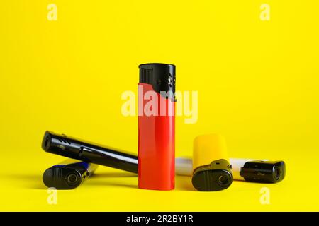 Petits briquets de poche élégants sur fond jaune Banque D'Images