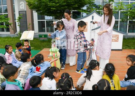 (230519) -- NANJING, 19 mai 2023 (Xinhua) -- Sun Jing (L) et Shi Jinfang enseignent aux enfants le contrôle des marionnettes dans un jardin d'enfants de la ville de Qidu, district de Wujiang dans la ville de Suzhou, province de Jiangsu, en Chine orientale, au 20 avril 2023. Kunqu, avec une histoire de centaines d'années, est classé par l'Organisation des Nations Unies pour l'éducation, la science et la culture (UNESCO) comme un patrimoine culturel intangible en 2001.dans la ville de Qidu de Suzhou, Il existe une forme unique de Kunqu Opera appelée « Kunqu Puppet » qui présente des acteurs présentant des performances avec des marionnettes sur la scène. Afin d'hériter de la traditionnelle 'Kunqu P Banque D'Images