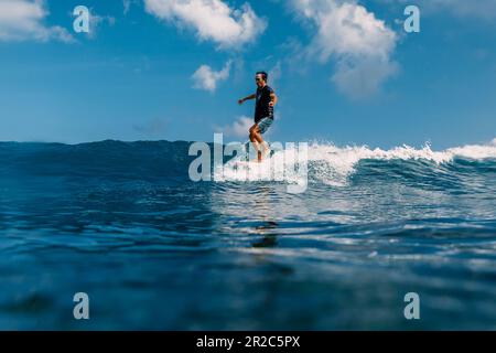 20 avril 2023. Bali, Indonésie. Surfeurs sur la planche de surf dans l'océan pendant le surf. Surfeur dansant à la planche de surf et à la vague Banque D'Images