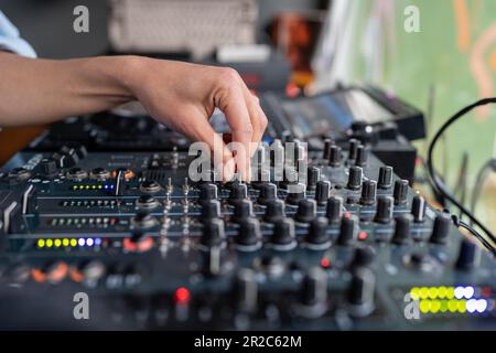 Femme radio DJ joue de la musique à la station de radio studio sur console de mixage, main gros plan. Banque D'Images