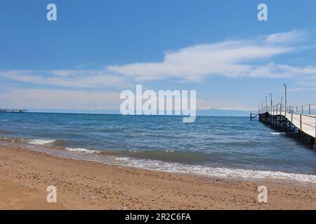 Paysage de mer avec jetée en bois gris menant à la mer, l'océan, lac avec ciel bleu. Concept de voyage, paysage marin, nature. Issyk-Kul, Kirghizistan. Copier l'espace Banque D'Images