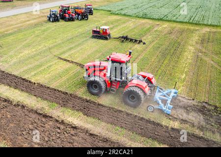 Une grande machine agricole cultive la terre. La vue du dessus. Labourage de terres pour la plantation de cultures. Photos de la vue de l'oiseau avec un quadc Banque D'Images
