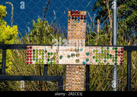 Perles de verre colorées sur une croix en bois dans un cimetière de l'Arizona après une tempête pendant la saison de la mousson Banque D'Images