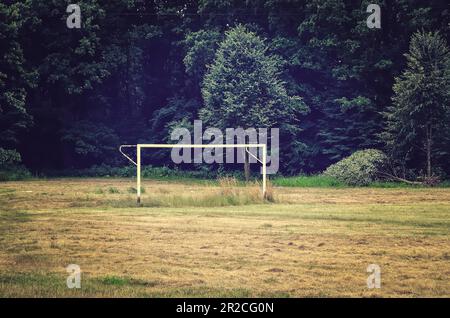 But de football dans un cadre de vieille école. Terrain de soccer et poteau de but sur un pré près de bois, but de soccer dans un quartier résidentiel local. Banque D'Images