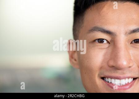 Demi-portrait d'un homme asiatique heureux et inaltérés souriant à l'appareil photo de l'hôpital, espace de copie Banque D'Images