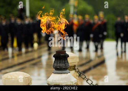 La flamme éternelle des héros de l'armée lors d'une cérémonie militaire à Bucarest, en Roumanie, à la tombe du Soldat inconnu, pendant une journée de pluie. Banque D'Images