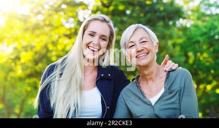 Portrait, femme âgée et fille adulte dans le parc, heureux à l'extérieur avec le hug, rire et passer du temps de qualité ensemble. Amour, confiance et relation Banque D'Images