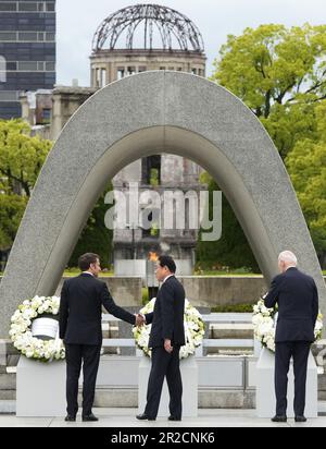 Hiroshima, Japon. 19th mai 2023. Le président français Emmanuel Macron (L) va serrer la main avec le Premier ministre japonais Fumio Kishida (C) aux côtés du président américain Joe Biden lors d'une cérémonie de pose d'une couronne de fleurs au Cenotaph pour les victimes de la bombe atomique dans le Parc commémoratif de la paix, dans le cadre du Sommet d'Hiroshima en G7 à Hiroshima, au Japon, du 19 mai 2023. (Photo de Franck Robichon/Pool) le Sommet d'Hiroshima G7 se tiendra du 19 au 21 mai 2023. (Credit image: © POOL via ZUMA Press Wire) USAGE ÉDITORIAL SEULEMENT! Non destiné À un usage commercial ! Banque D'Images