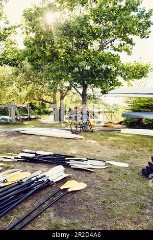 Kayaks et paddles se trouvant sur le sol dans une petite entreprise de location de kayak Banque D'Images