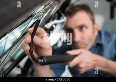 Mechanic repairing a location in workshop Banque D'Images