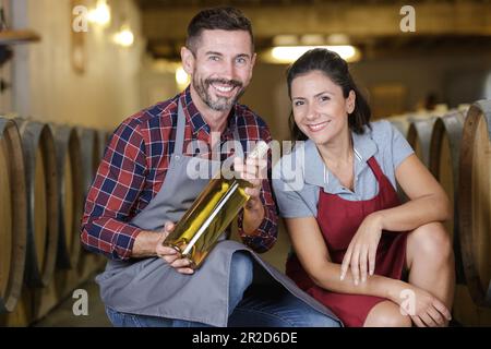 couple amoureux du vin tenant une bouteille de vin dans la cave Banque D'Images