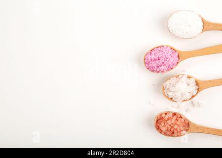 Divers types de sel de mer spa dans des cuillères en bois isolées sur fond blanc. Vue de dessus Banque D'Images