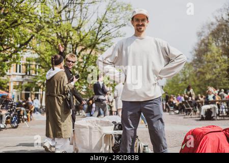 l'homme se tient heureux et fier au marché de la fuite de seconde main en europe Banque D'Images