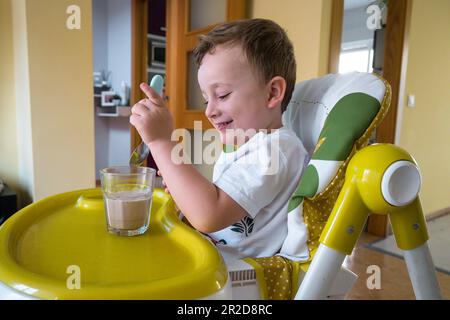 Très bel enfant prenant le petit déjeuner avec des céréales et du lait Banque D'Images