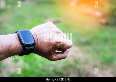 Montre noire sur le poignet gauche pour homme pour regarder tout en s'entraînant. Concept de surveillance des systèmes de corps avec un dispositif porté sur le poignet du Banque D'Images