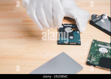 nouveau concept de réparation et de réparation de l'ordinateur à disque dur pour la récupération des données et la sauvegarde sur le stockage. Main de l'ingénieur tenant le disque dur ou le disque pour la réparation, réparer Ba Banque D'Images