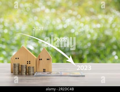 Maison en bois simulée sur le fond herbe floue dans le jardin avec un espace de copie côté supérieur. Concept de budget immobilier, pile, argent, pièces Banque D'Images