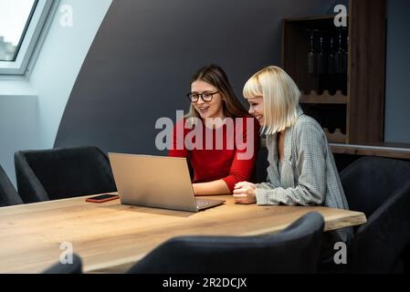 Deux jeunes femmes d'affaires discutent avec la présentation de l'idée du nouveau projet de démarrage, analysent la planification et les statistiques financières et le marché de l'investissement au bureau Banque D'Images