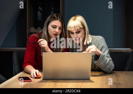 Deux jeunes femmes d'affaires discutent avec la présentation de l'idée du nouveau projet de démarrage, analysent la planification et les statistiques financières et le marché de l'investissement au bureau Banque D'Images