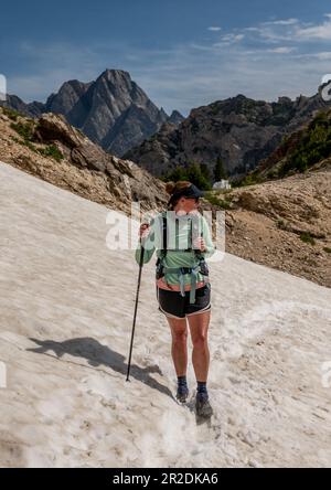 La zone de neige de femelle Hiker Crossing sur le sentier Peintbrush Divide dans le parc national de Grand Teton Banque D'Images