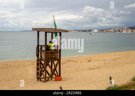 Palma de Majorque, Espagne - 13 mai 2023 : sauveteur dans une tour en bois sur la plage avec la marina de Palma en arrière-plan Banque D'Images