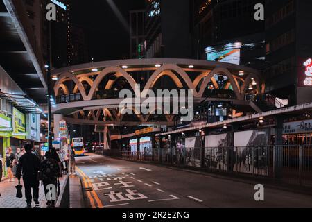 Hong Kong, Chine - 10 avril 2023 : structure circulaire en forme de pont piétonnier dans la baie de Causeway la nuit Banque D'Images