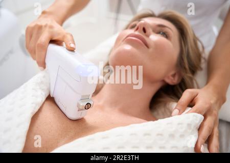 Le patient subit une procédure non chirurgicale de serrage de la peau dans la zone du décolleté Banque D'Images