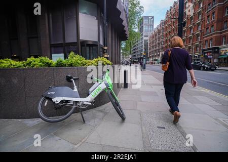 Londres, Royaume-Uni. 19 mai 2023 Un vélo électrique Lime Location abandonné dans la rue Victoria Westmiinster. Les compagnies de location de vélos électriques telles que Lime by Uber, Human Forest, et dott, n'ont pas de places de stationnement contrairement à Santander. Le Conseil de Westminster élabore des plans pour les cavaliers qui ne parcoutent pas correctement leurs cycles loués laissés sur des trottoirs qui peuvent poser une obstruction aux piétons et aux utilisateurs de fauteuils roulants. Credit: amer ghazzal / Alamy Live News Banque D'Images