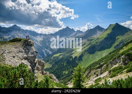 Deux personnes se tiennent sur l'éperon rocheux et regardent Hochvogel, Jubiläumsweg, Allgäu Alpes, Oberallgäu, Allgäu, Swabia, Bavière, Allemagne Banque D'Images