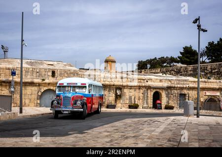 Valletta, Malte - 18 avril 2023: Un bus maltais vintage, rouge, blanc et bleu, garé dans la rue du centre-ville. Banque D'Images