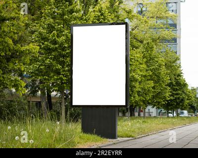 Modèle de publicité extérieure avec écran vierge. Vider le panneau d'affichage à côté d'un trottoir. Zone urbaine avec publicités commerciales dans l'espace public. Banque D'Images