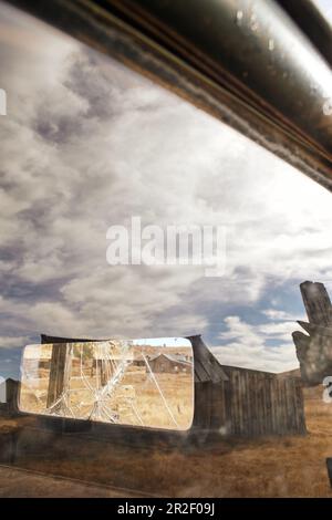Vue sur un miroir arrière cassé dans la ville fantôme de Bodie. Eastern Sierra, Californie, États-Unis. Banque D'Images