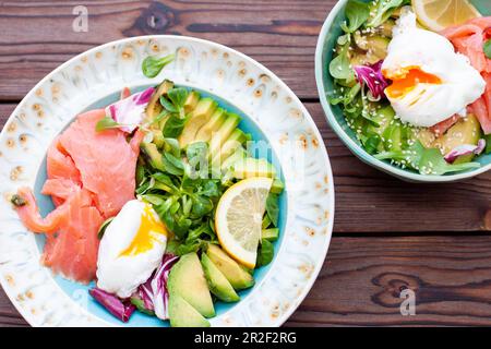 Brunch avec œufs pochés, avocat, arugula, graines de lin et saumon salé sur fond de bois rustique. plat, horizontal. copier l'espace Banque D'Images