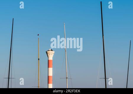 Un phare sur l'Elbe encadré par les mâts de certains voiliers, Blankenese, Hambourg, Allemagne Banque D'Images